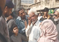a family member of a gul plaza salesman wipes away tears while standing before the charred remains of the building mourning the loss of a lifetime of work and memories in the devastating fire photo app