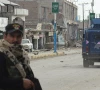 a police officer stands guard on a street with damaged shops in the background in bannu khyber pakhtunkhwa photo afp