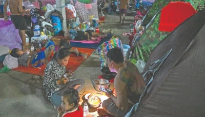 a displaced family uses a flashlight as they eat a meal at a temporary camp along the cambodia thailand border photo afp a displaced family uses a flashlight as they eat a meal at a temporary camp along the cambodia thailand border photo afp