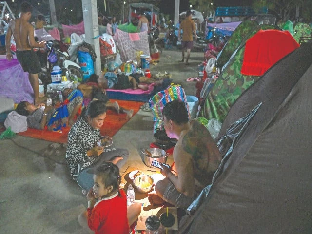 a displaced family uses a flashlight as they eat a meal at a temporary camp along the cambodia thailand border photo afp a displaced family uses a flashlight as they eat a meal at a temporary camp along the cambodia thailand border photo afp