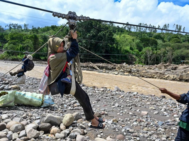 people use a rope to cross a river in the aftermath of flash floods that destroyed adjacent villages in ketol indonesia s aceh highland province on january 6 2026 photo afp people use a rope to cross a river in the aftermath of flash floods that destroyed adjacent villages in ketol indonesia s aceh highland province on january 6 2026 photo afp