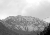 the snowcovered slopes set against a dramatic overcast sky and framed by towering evergreen trees offer a striking glimpse of the region s natural beauty as the weather turns colder photo online