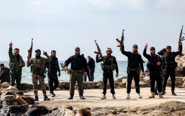 members of security forces loyal to the interim syrian government pose by the mediterranean coast in syria s western city of latakia photograph photo afp