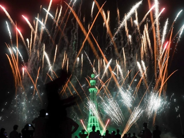 people watch fireworks exploding over the illuminated minar e pakistan monument during the celebration of independence day in lahore on august 14 2025 photo reuters
