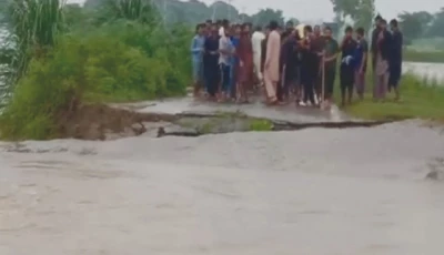 people stand near a damaged road in a flooded area of narowal district photo nni
