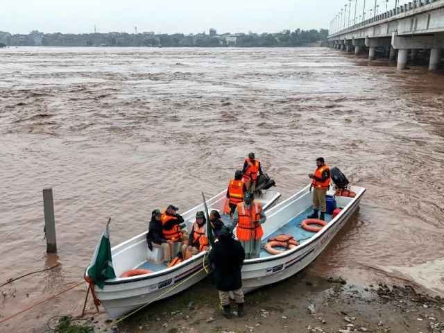 this aerial photograph shows rescue personnel preparing to patrol along the flooded ravi river following a rise in water levels near residential areas in shahdara lahore on august 29 2025 photo afp