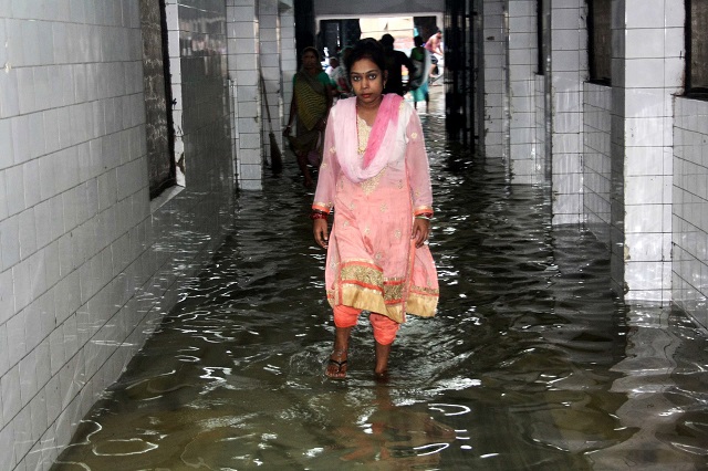 a woman walking along a waterlogged corridor at Nalanda Medical College. PHOTO: AFP