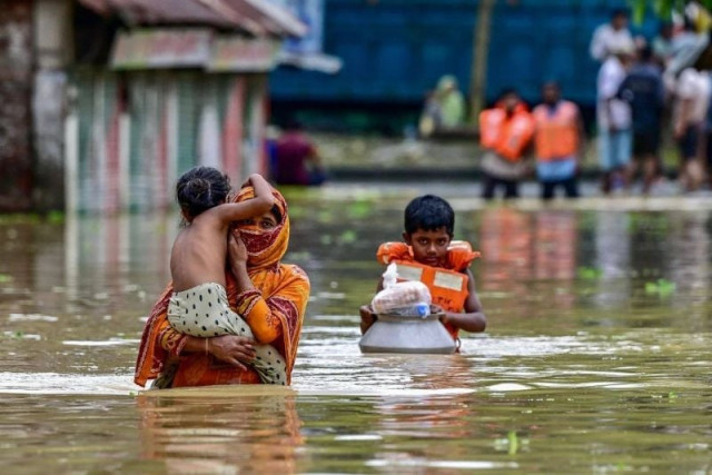 people wade through flood waters after collecting relief materials in feni in south eastern bangladesh on august 24 2024 photo afp people wade through flood waters after collecting relief materials in feni in south eastern bangladesh on august 24 2024 photo afp