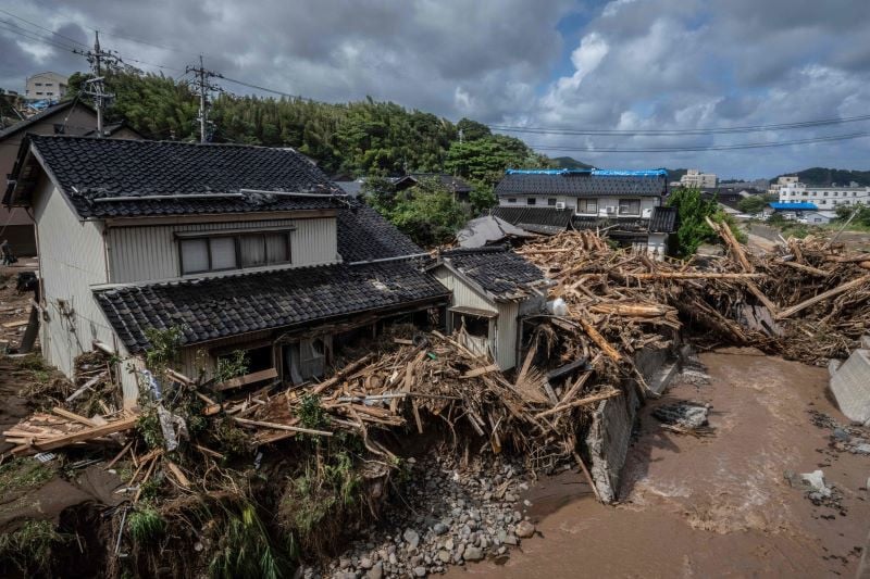 debris washed away from flooding is seen piled by houses along the tsukada river following heavy rain in wajima city ishikawa prefecture on september 23 2024 heavy rain that triggered floods and landslides on a japanese penisula recovering from an earthquake this year killed at least six people local media reported on september 23 photo afp