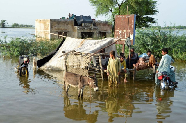 people are seen outside their flooded house following rains and floods during the monsoon season in sohbatpur pakistan august 28 2022 photo reuters