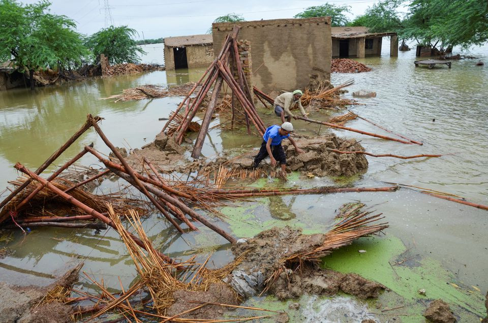 people retrieve bamboos from a damaged house following rains and floods during the monsoon season in dera allah yar district jafferabad balochistan photo reuters