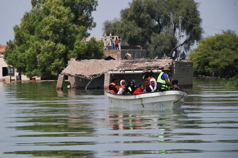 rescued flood victims sit in a boat following rains and floods during the monsoon season in village arazi in sehwan pakistan september 11 2022 photo reuters