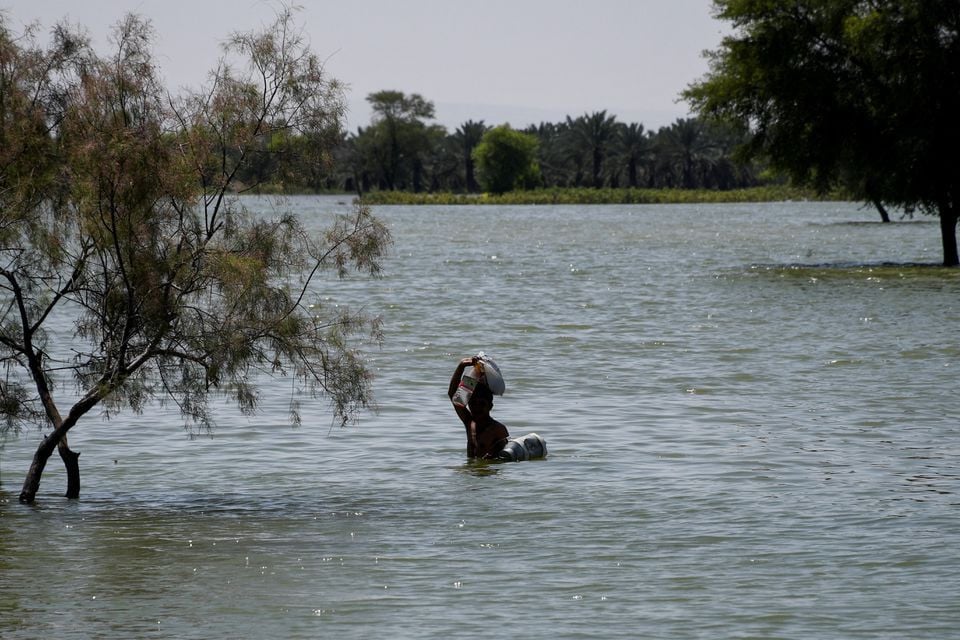 a flood victim wades through flood water following rains and floods during the monsoon season in bajara village sehwan pakistan august 31 2022 photo reuters