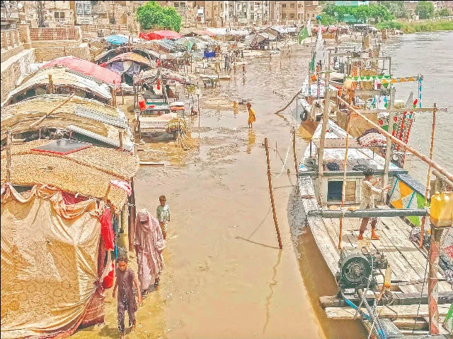 residents wade through murky floodwaters in sukkur as overflowing waters from the indus river submerge nearby riverside settlements amid a low level flood photo ppi