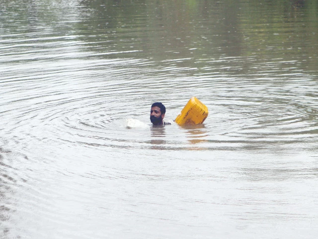 a farmer swims while using an empty canister through a flooded area near qasim bela village on the outskirts of multan photo reuters a farmer swims while using an empty canister through a flooded area near qasim bela village on the outskirts of multan photo reuters