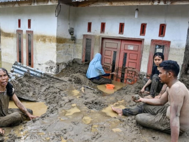 dozens of people were killed in indonesia s aceh province where residents cleared mud from flooded homes photo afp