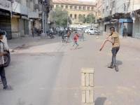 flour fury youngsters play cricket outside shuttered shops in jodia bazaar during a traders strike on wednesday photos jalal qureshi express