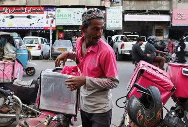 a foodpanda delivery rider loads items into his delivery box before delivering them in karachi pakistan march 13 2026 photo reuters