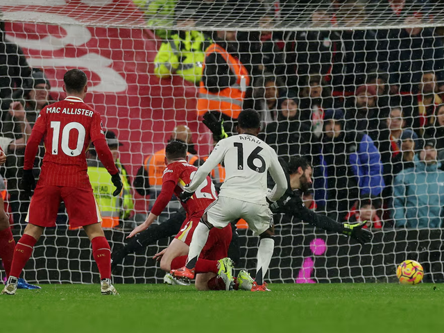 Amad Diallo dari Manchester United mencetak gol kedua mereka melewati pemain Liverpool Alisson Becker. Foto: Reuters