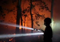 a firefighter sprays water to extinguish flames in the fontainebleau forest during a wildfire in le vaudoue during a heatwave affecting large parts of france july 13 2026 photo reuters file