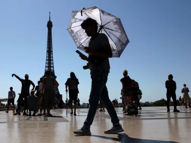a tourist holding an umbrella to protect himself from the sun walks at trocadero square next to the eiffel tower as an early summer heatwave hits paris france photo reuters