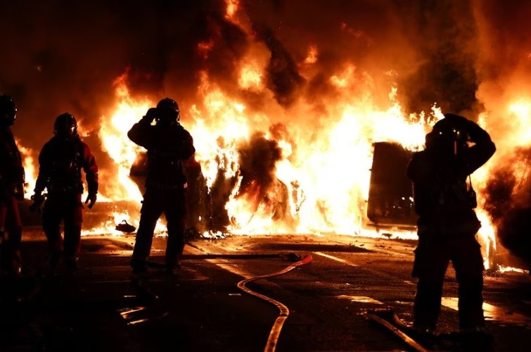 firefighters stand as they extinguish burning vehicles during clashes between protesters and police after the death of nahel a 17 year old teenager killed by a french police officer during a traffic stop in nanterre paris suburb france june 28 2023 reuters stephanie lecocq