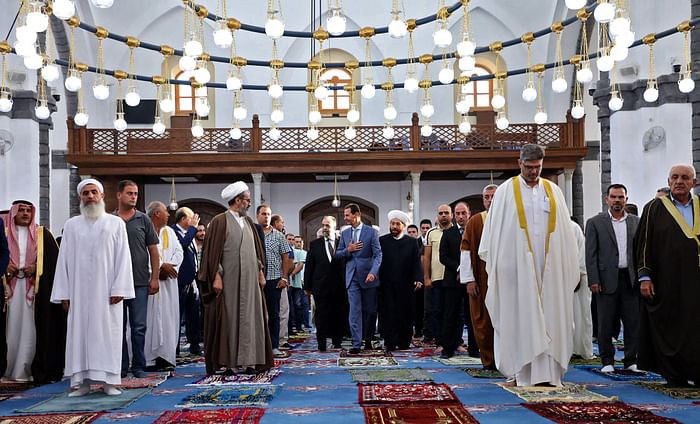 A handout picture released by the official Facebook page of the Syrian Presidency shows President Bashar al-Assad (C) performing Eidul Azha prayer at Khaled bin al-Walid mosque in Homs on July 20, 2021. PHOTO: AFP