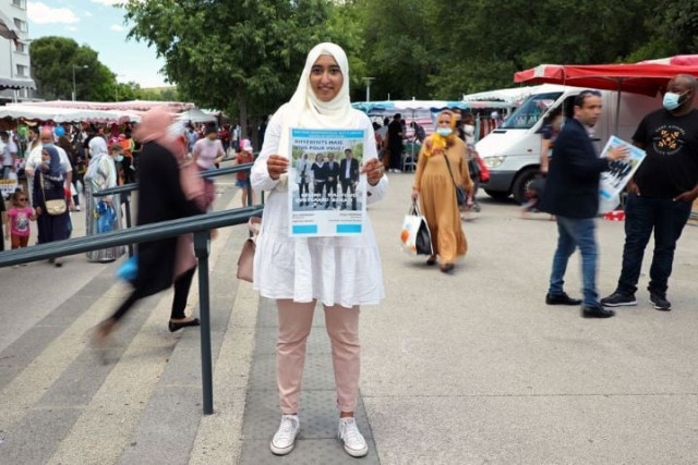 french local election candidate sara zemmahi wearing a hijab holds her campaign flyer with the slogan different but united for you as she poses during an interview for reuters ahead of the upcoming french local elections in the la mosson market in montpellier france june 5 2021 picture taken june 5 2021 reuters yiming woo french local election candidate sara zemmahi wearing a hijab holds her campaign flyer with the slogan different but united for you as she poses during an interview for reuters ahead of the upcoming french local elections in the la mosson market in montpellier france june 5 2021 picture taken june 5 2021 reuters yiming woo