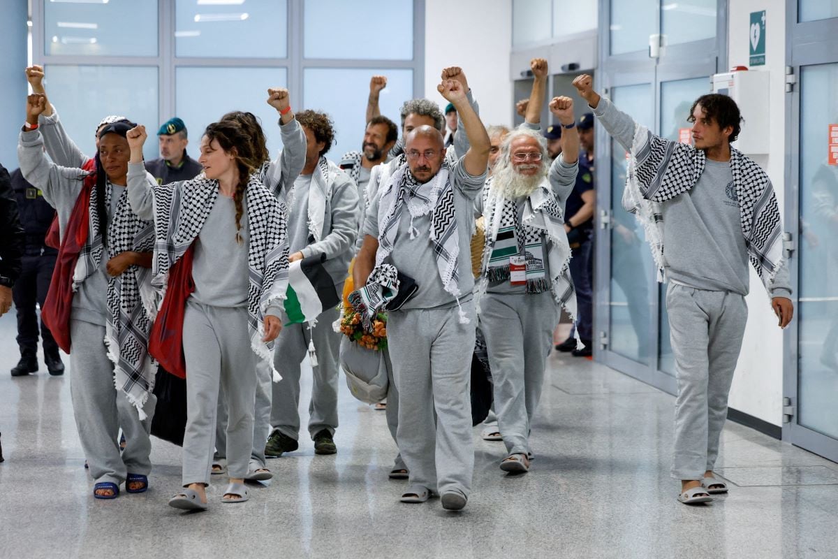 Italian activists from the Gaza-bound Global Sumud Flotilla, detained by Israeli forces after their vessels were intercepted in international waters in the Mediterranean, gesture upon arrival at Fiumicino Airport, in Fiumicino, Italy, May 21, 2026. REUTERS