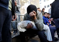a palestinian man carries the body of his 5 month old brother ahmed al nader who was reportedly killed the previous day along with other family members in an israeli shelling on a school turned shelter in the tuffah neighbourhood of gaza city ahead of his funeral photo afp