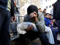 a palestinian man carries the body of his 5 month old brother ahmed al nader who was reportedly killed the previous day along with other family members in an israeli shelling on a school turned shelter in the tuffah neighbourhood of gaza city ahead of his funeral photo afp