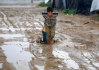 a barefoot boy pulls a water container along a muddy road after heavy rain at the bureij camp for palestinian refugees in the central gaza strip on february 24 2026 photo afp