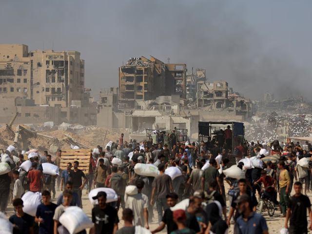 Palestinians carry aid supplies that entered Gaza through Israel, in Beit Lahia in the northern Gaza Strip, July 27, 2025. Photo: Reuters