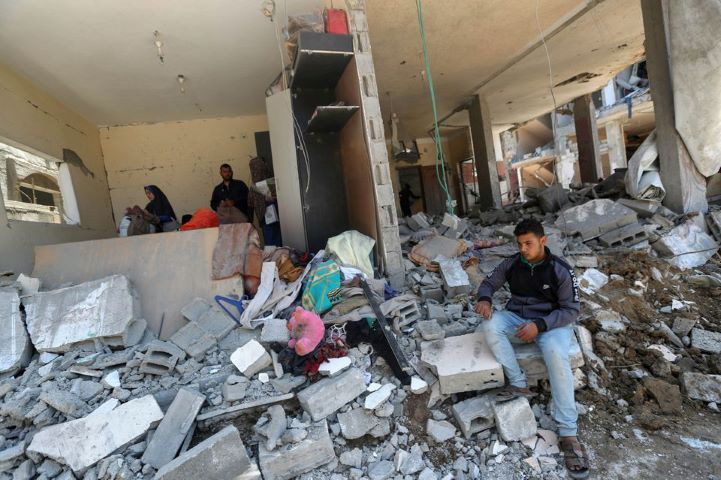 a palestinian boy sits on debris at the site of destroyed houses in the aftermath of israeli air and artillery strikes as cross border violence between the israeli military and palestinian militants continues in the northern gaza strip may 14 2021 reuters mohammed salem