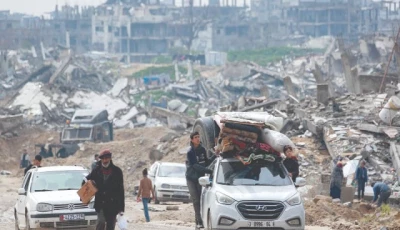 boys ride outside a vehicle loaded with mattresses blankets and a giant cistern moving along a road in the west of beit lahia in the northern gaza strip photo afp