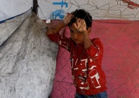 a displaced palestinian child who fled gaza city due to an israeli military operation stands by a fence as he rests on the roadside in the central gaza strip october 5 2025 photo reuters