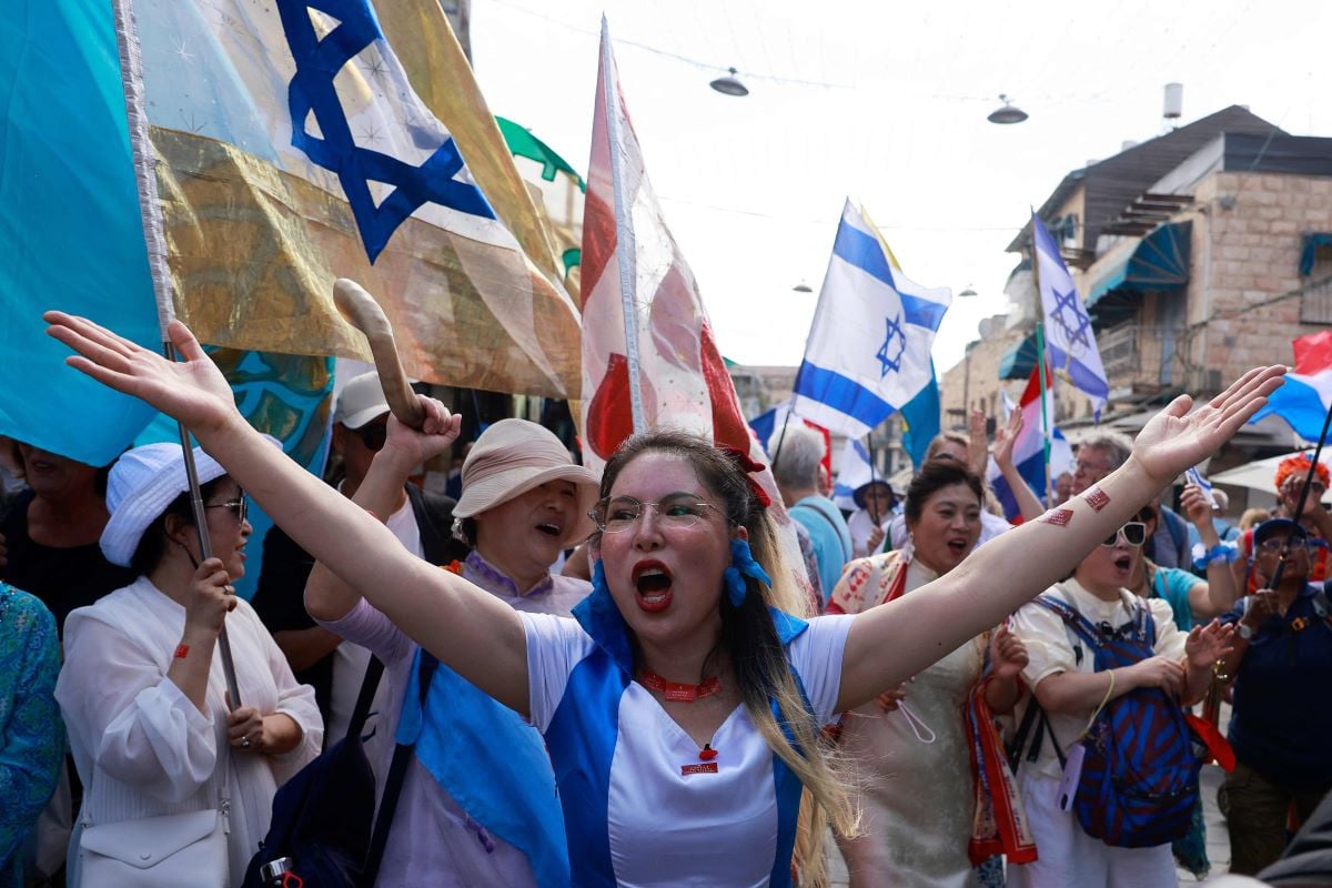 Foreign Christian pilgrims and other supporters of a ceasefire deal march through the Mahane Yehuda market in Jerusalem as they celebrate the Jewish holiday of Sukkot, also known as the Feast of Tabernacles, on October 9, 2025.PHOTO: AFP