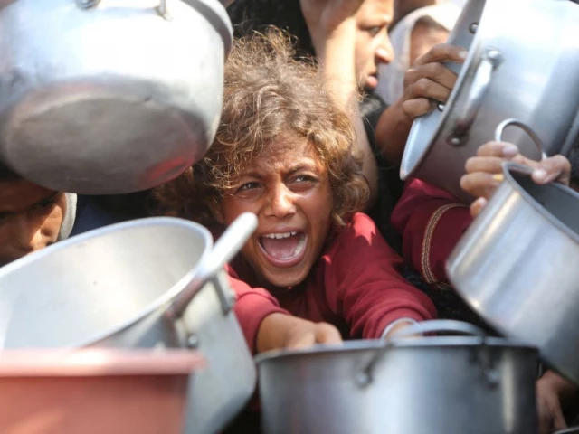 a child reacts surrounded by pots as palestinians wait to receive food from a charity kitchen in khan younis southern gaza strip august 21 2025 photo reuters