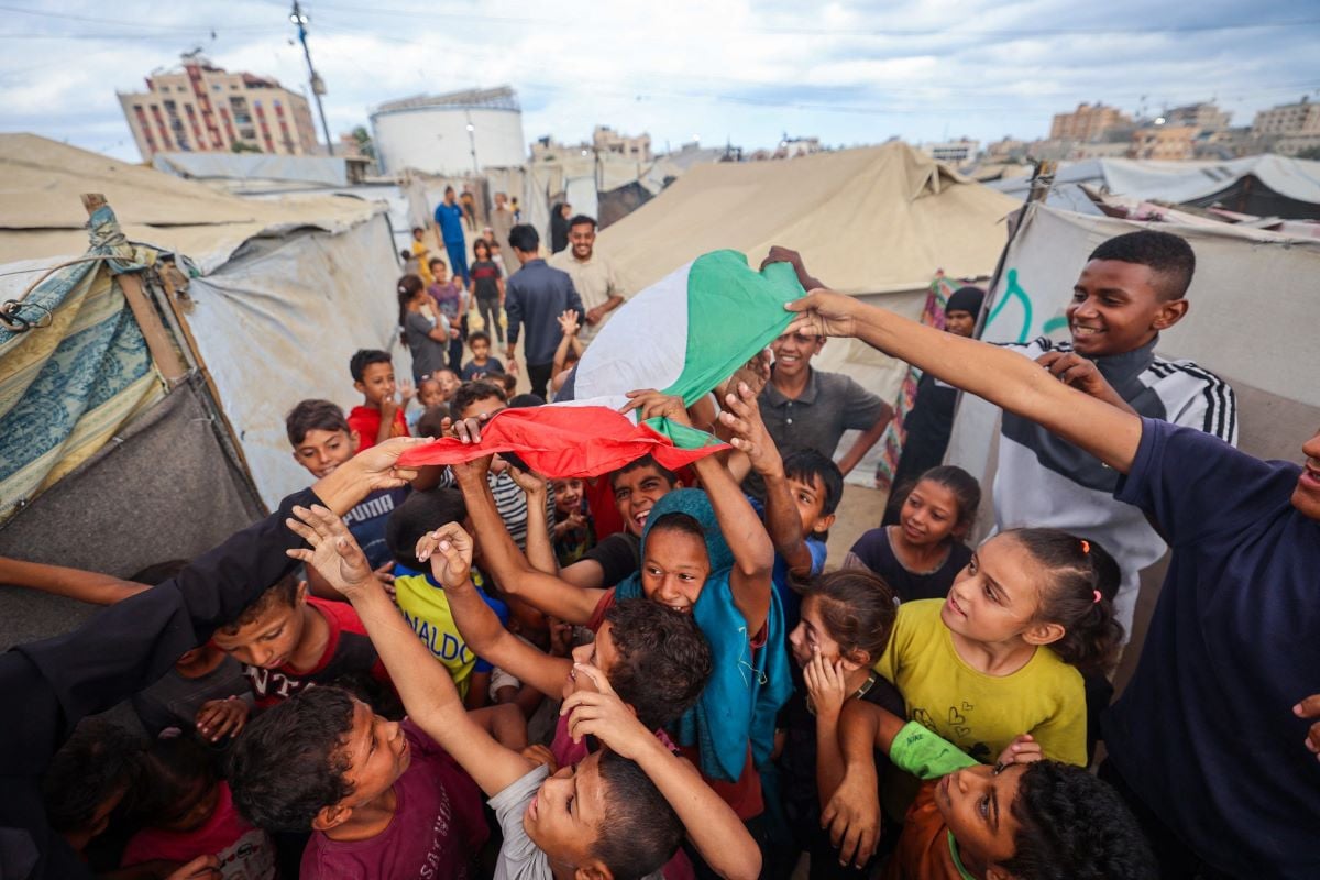 Palestinian children celebrate at a camp for displaced people in Nuseirat in the central Gaza Strip on October 9, 2025, following news of a new Gaza ceasefire deal. Israel and Hamas on October 9 agreed a Gaza ceasefire deal to free the remaining living hostages, in a major step towards ending a war that has killed tens of thousands of people and unleashed a humanitarian catastrophe. PHOTO: AFP