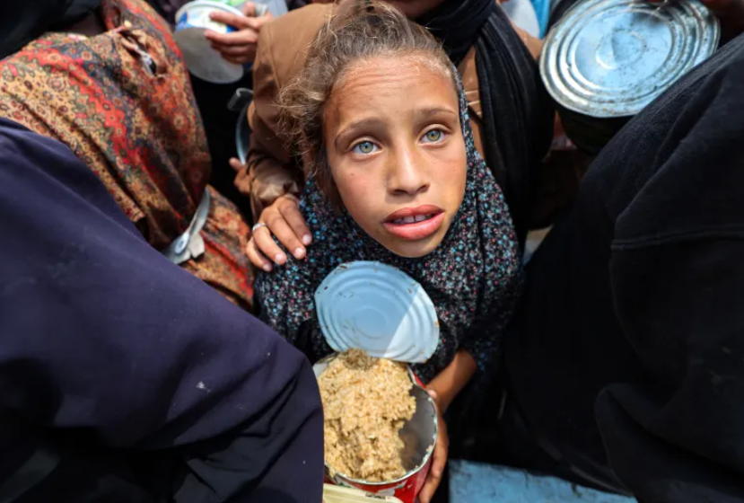 A Palestinian girl holds a container at a food distribution point in the Nuseirat camp for refugees in the central Gaza Strip on May 21, 2025. PHOTO: AFP