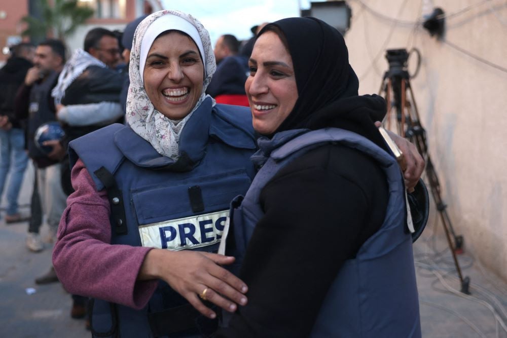 Mariam Dagga (L), a Palestinian visual journalist who freelanced for AP since the start of the war, hugs a fellow journalist in Khan Yunis in the southern Gaza Strip on January 18, 2025. The Foreign Press Association on August 25, called for an 