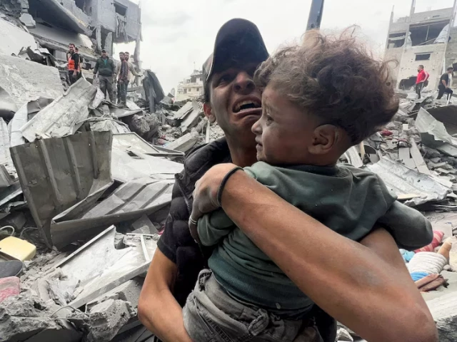 a palestinian man reacts as he holds a child at the site of an israeli strike on a house in shejaia in gaza city photo reuters a palestinian man reacts as he holds a child at the site of an israeli strike on a house in shejaia in gaza city photo reuters