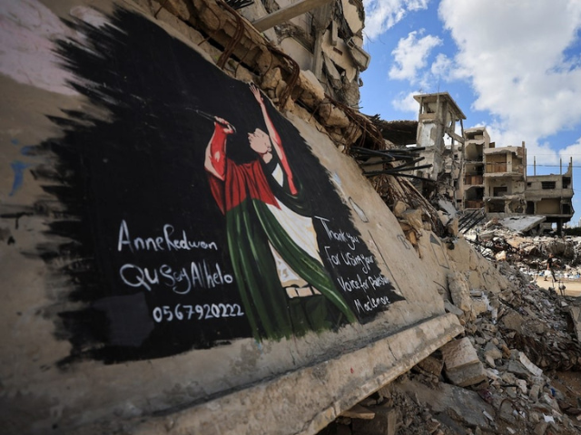 Palestinians walk near a mural painted in honour of American rapper Macklemore, amid buildings destroyed during the war, in Gaza City, September 18, 2026. PHOTO: Reuters