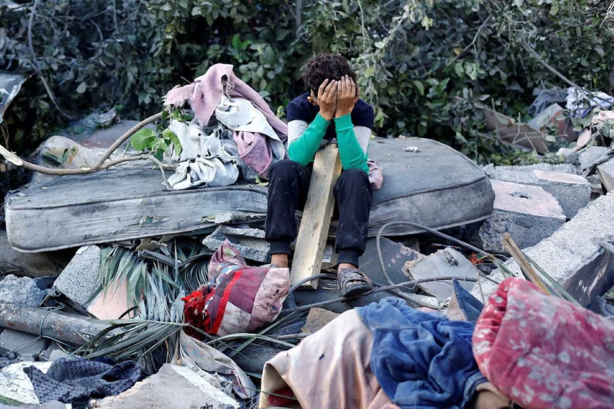 A Palestinian boy reacts as he sits at the site of an overnight Israeli strike on a house, in Nuseirat, central Gaza Strip, October 29, 2025.PHOTO: REUTERS