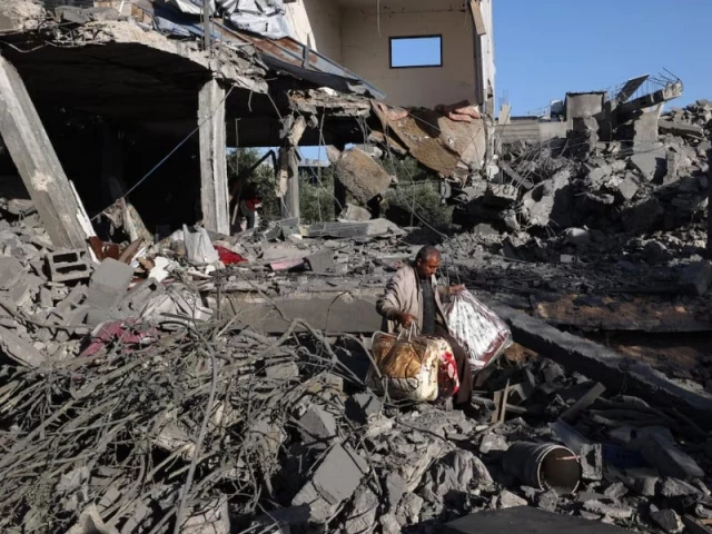 a palestinian man carries items he salvaged from a house targeted in an israeli strike at the nuseirat camp for refugees in the central gaza strip on may 24 photo afp a palestinian man carries items he salvaged from a house targeted in an israeli strike at the nuseirat camp for refugees in the central gaza strip on may 24 photo afp