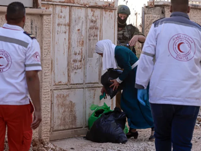 paramedics help a palestinian woman carry her belongings as an israeli soldier enforces a displacement order on a house in the jenin refugee camp in the israeli occupied west bank on tuesday paramedics help a palestinian woman carry her belongings as an israeli soldier enforces a displacement order on a house in the jenin refugee camp in the israeli occupied west bank on tuesday