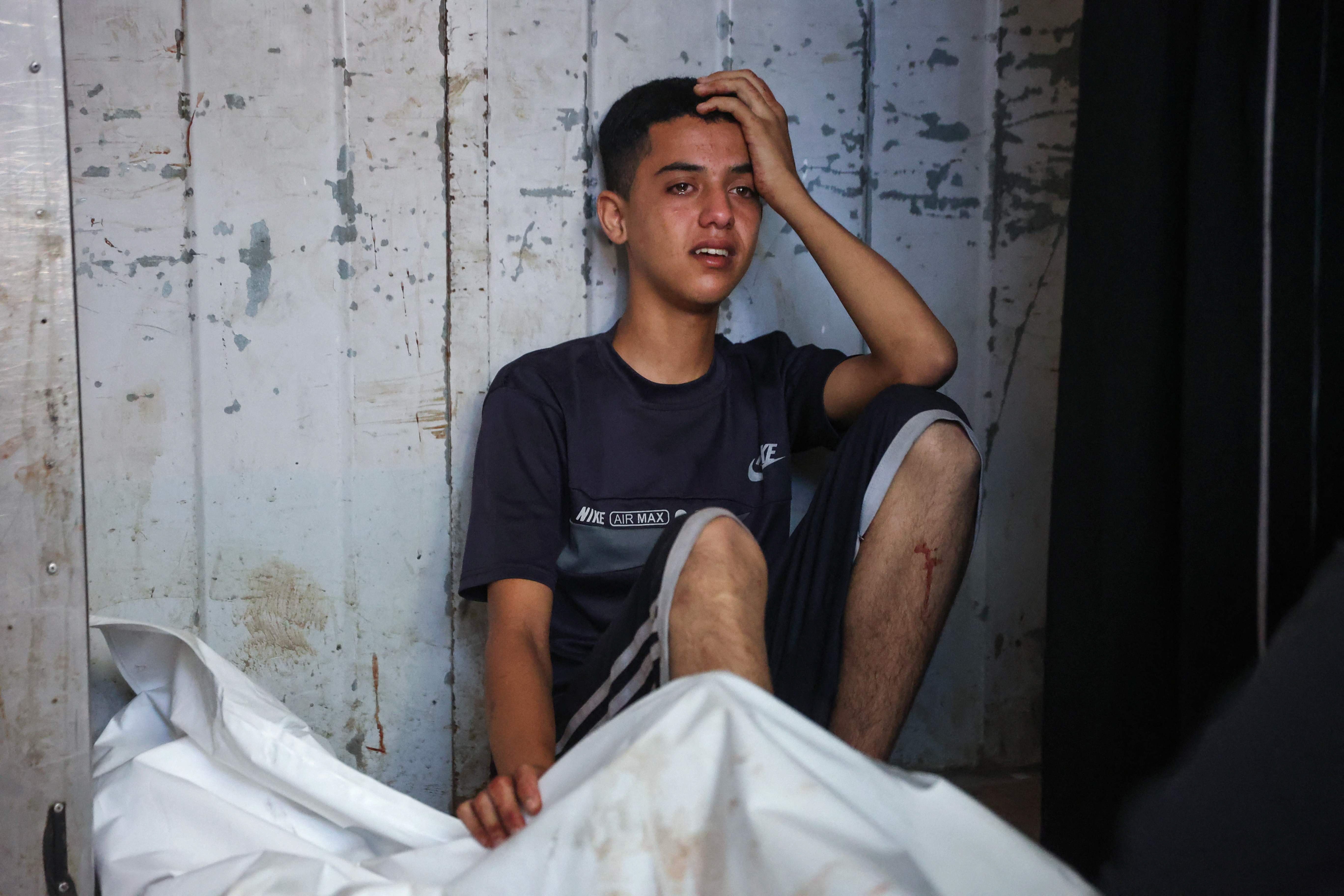 A Palestinian youth mourn by the body of a relative killed in Israeli strikes on Gaza City at dawn, at the Al-Shifa hospital on September 2, 2025. Photo: AFP