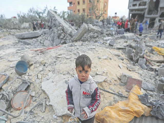 a child looks on as palestinians inspect the site of an israeli strike on a house in khan younis photo reuters a child looks on as palestinians inspect the site of an israeli strike on a house in khan younis photo reuters