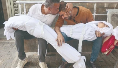 a palestinian man is comforted by a relative as he mourns over the bodies of his children who were killed in overnight israeli strikes at the al shifa hospital in gaza city photo afp