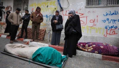 mourners gather next to bodies as they attend the funeral of palestinians who according to medics were killed after a wall collapsed at a war damaged building on a windy winter day at al shifa hospital in gaza city january 13 2026 photo reuters